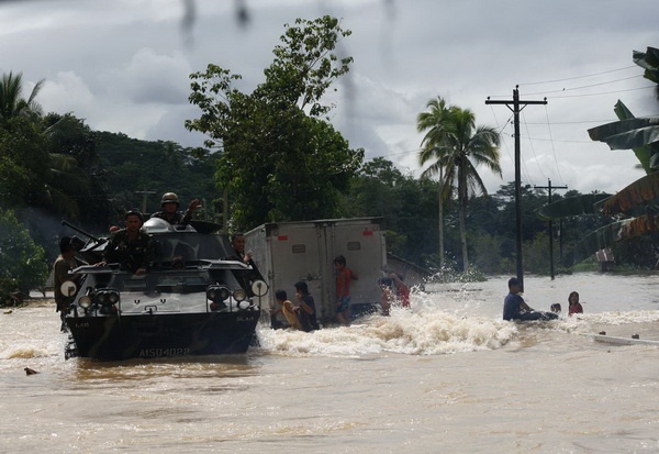 A military convoy carrying relief goods navigates through the flooded national highway on Thursday at Barangay San Roque in Kitcharao, Agusan del Norte. Elements of the Charlie Company of the 30th Infantry Battalion transported relief goods from Butuan City to Mainit town, in Surigao del Norte. Mindanews Photo by Ruby Thursday More