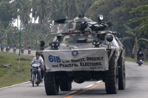A streamer calling for a peaceful and orderly elections is   displayed  as Army troopers and tanks patrol the highway in Maguindanao   province on May 10, 2010. MindaNews photo by Froilan Gallardo
