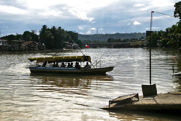 CHEAP ALTERNATIVE. A small ferry carrying passengers from S.I.R Matina plies Bankerohan River in Davao City on Thursday, July 14, 2011. Charging P1 for students and P2 for regular passengers, the ferry provides cheap transport for people going to the downtown area in Davao City. MindaNews photo by Ruby Thursday More