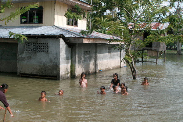 Children frolic in murky flood waters on Tuesday (27 Sept. 2011) in Barangay Taviran, Kabuntalan, Maguindanao. The province has declared a state of calamity because of the floods that affected 16 towns. MindaNews photo by Gigi Bueno
