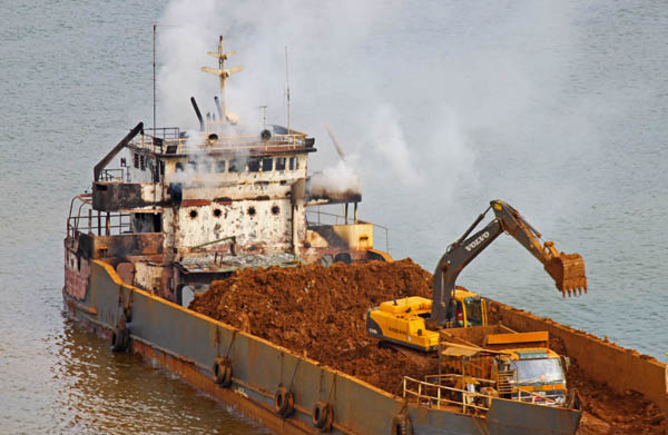 A barge smolders at anchor at the Cagdianao pier of Platinum Group Metals Corporation in in Barangay Cagdianao in Claver town, Surigao del Norte on Tuesday, Oct. 4, 2011. NPA rebels attacked three mining firms in Claver on Oct. 3 destroying hundreds of millions pesos of heavy mining equipment including barges. MindaNews photo by Roel Catoto