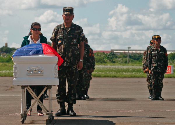 Jennifer Mabalot meets the remains of her slain husband, Sgt. Bonifacio Mabalot, among the 19 Army soldiers who died in the clash with Moro rebels in Basilan last Tuesday (Oct. 19, 2011), at the Tactical Operations Group located at the old airport in Sasa, Davao City on Friday (Oct. 21, 2011). Mabalot's body will be brought to Tagum City. MindaNews Photo by Ruby Thursday More