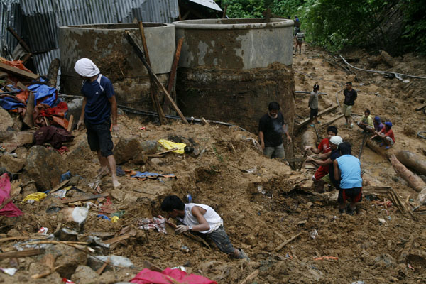 LANDSLIDE. Rescuers dig through the dirt and rubble at the landslide site in Barangay Napnapan, Pantukan, Compostela Valley on Thursday, January 5. At least 18 persons were killed while eight others were reported missing. MindaNews Photo by Ruby Thursday More