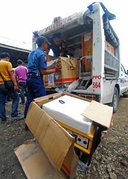 STANDBY POWER. Police officers load a generating set to their car for deployment in barangays in Lanao del Sur that have no electricity, on July 8, 2012. The Commission on Elections has initiated a re-registration of voters for Lanao del Sur and the four other provinces in the Autonomous Region in Muslim Mindanao on July 9 to 18. MindaNews photo by Froilan Gallardo