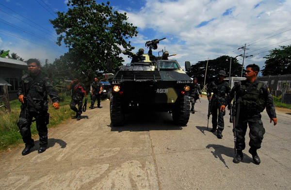 SEARCH OPERATIONS. Inch by inch, policemen clear the vital highway linking Cotabato and Isulan cities on August 10, 2012. After the highway was closed for five days, the military said they have finally cleared the highway of rebel snipers and declared it safe for motorists. MindaNews photo by Froilan Gallardo