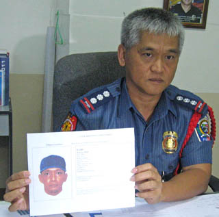 WHO'S HE? Senior Supt. James Mejia of the Zamboanga police shows the sketch of one of the four suspects in the bus bombing in Zamboanga City last August 16, 2012. MindaNews photo