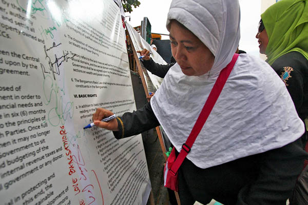 PLEDGE. A Moro woman joins in the symbolic signing of the GPH-MILF Framework Agreement at the Freedom Park in Davao City on Oct. 15, 2012. Participants in the symbolic signing pledgeed to support the call for peace in Mindanao. MindaNews photo by Ruby Thursday More