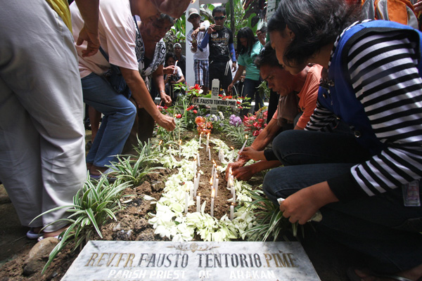 IN MEMORY OF. Parishioners and friends of slain Italian missionary Fr. Fausto "Pops" Tentorio, PIME light candles at his grave at the compound of the Bishop's Residence in Barangay Balindog, Kidapawan City on Wednesday, October 17 to commemorate his first death anniversary. Fr. Pops was killed last year by still unidentified men at his parish compound in Arakan, North Cotabato. MindaNews Photo by Ruby Thursday More 