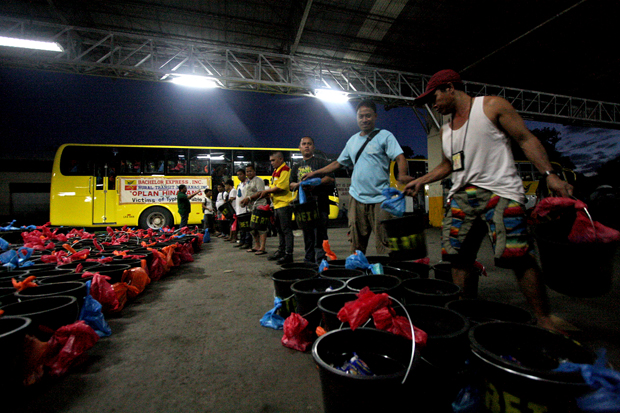 Workers of Bachelor Express and Rural Transit Mindanao bus lines load relief goods onto a bus on Monday night, December 17 at their headquarters in Maa, Davao City. The relief goods--consisting of pails, noodles, sardines, medicines and rice--will be delivered today, December 18 to typhoon stricken areas in Compostela Valley and Davao Oriental Provinces. MindaNews Photo by Ruby Thursday More