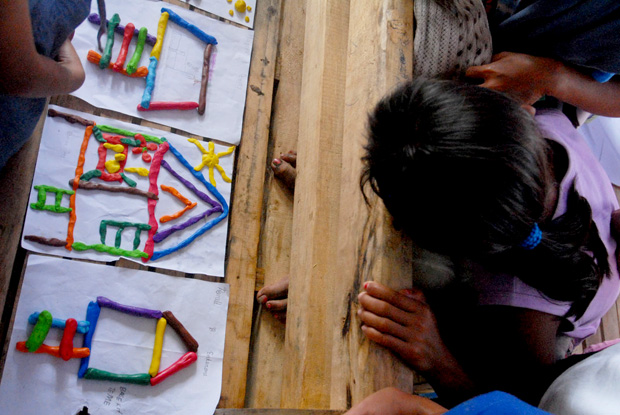 CLOSE LOOK. A child climbs up the chair to look closely at the drawings of other children. Psycho social teams have conducted trauma debriefings among the children in Barangay Banao in Baganga town in Davao Oriental on Dec. 27, 2012. MindaNews photo by Froilan Gallardo
