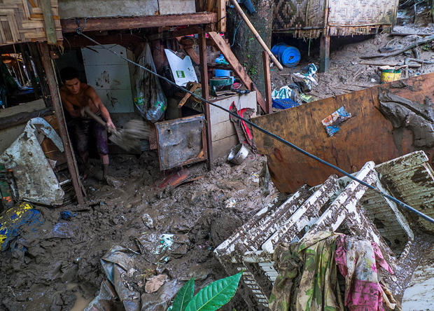 AFTERMATH. A resident shovels mud out of his house, a day after the Davao River spilled and flooded Awhag Village in Bacaca Road, Davao City on Jan. 21, 2012. The flood forced the evacuation of at least 2,000 families living beside the river. MindaNews photo by BJ Patino