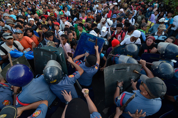 After the looting of relief packs by ‘Pablo’ victims at the Department of Social Welfare and Development regional office in Davao City last Tuesday (26 February 2013), angry protesters engage policemen in a brawl to reclaim their position. But protesters failed to recover the looted goods as the policemen dispersed the crowd. Mindanews Photo