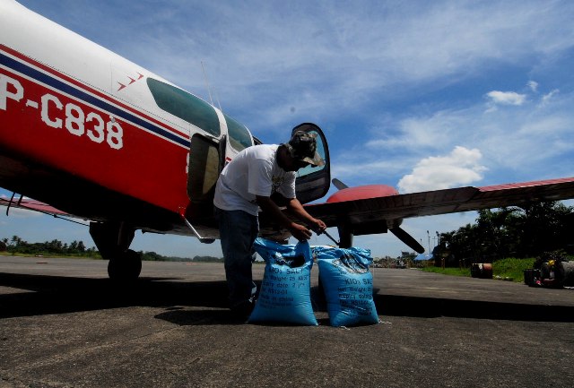 CLOUD SEEDING.Department of Agriculture workers load sacks of vacuum dried salt into a Beechcraft Baron plane in Lumbia Airport, Cagayan de Oro City on April 12, 2013 for cloud seeding operation to induce rains at Lake Lanao, which feeds water to the Agus hydropower plants, one of Mindanao’s major sources of electricity. MindaNews photo by Froilan Gallardo