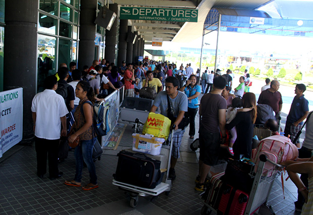 Passengers mill outside the departure area of the Francisco Bangoy International Airport in Davao City Monday morning (3 June 2013). The DOTC reported that at least 10 flights to Davao City have already been cancelled as the Cebu Pacific flight 5J 971 that overshot the runway the night before is still stuck on runway as of Monday morning. Mindanews Photo by Keith Bacongco
