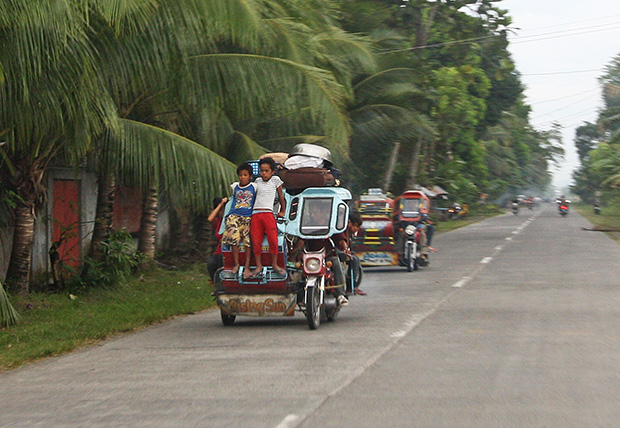 Young boys stand on the 'bumper' of a speeding tricycle, unmindful of the danger on Tuesday, September 24 in Barangay Tumbras, Midsayap town, North Cotabato Province. These boys are heading home after spending a night at the evacuation center when the Bangsamoro Islamic Freedom Fighters attacked several barangays in Midsayap on Monday. MindaNews Photo by Ruby Thursday More