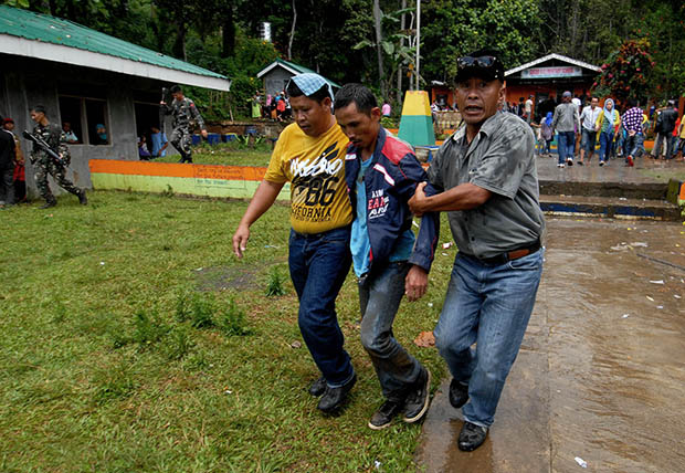 INJURED SUPPORTER. Companions of an injured political supporter bring him out after a fistfight that resulted to police firing warning shots at Sugod Elementary School in Tugaya town, Lanao del Sur on Election day, Oct. 28, 2013. MindaNews photo by Froilan Gallardo