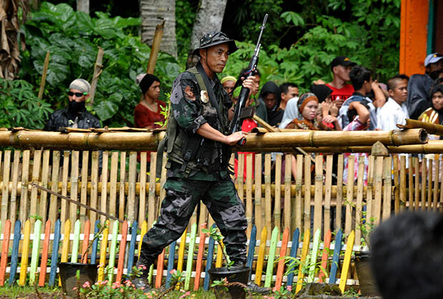WARNING SHOTS. A police officer fires shots in the air to stop the fighting between political supporters at Sugod Elementary School in Tugaya town, Lanao del Sur on Election day, Oct. 28, 2013. MindaNews photo by Froilan Gallardo