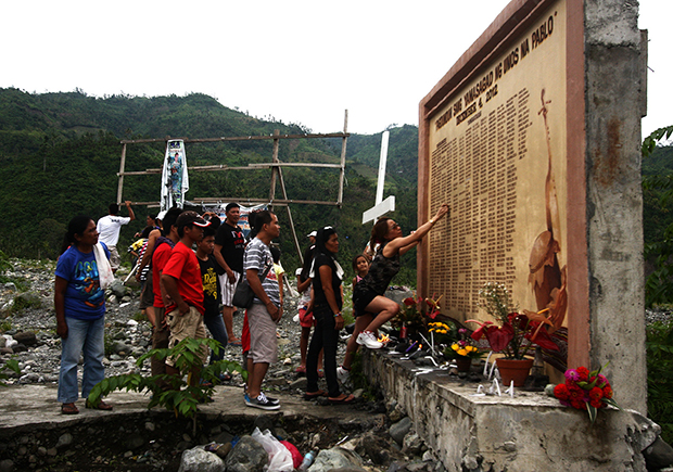 woman erases on Friday the name of her relative who was believed to be alive but listed in the marker as among those killed when flashflood hit Barangay Andap in New Bataan, Compostela Valley on December 4, 2012. At least 436 people were killed while about 400 others were missing when super typhoon Pablo hit New Bataan. MindaNews photo by Ruby Thursday More
