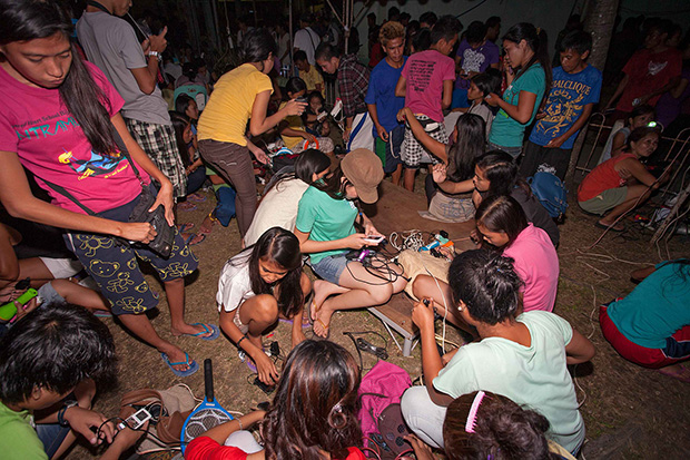 HARGING PICNIC. Because there's still no power in the households, residents of Palompon, Leyte gather at the public plaza at night to charge cellphones, flashlights and other rechargeable devices with electricity provided by the municipal government for free. Otherwise, one has to pay P15 an hour to charge devices elsewhere. Photo taken Wednesday, 27 Nov 2013. MindaNews photo by Bobby Timonera.