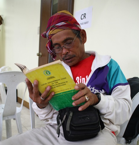 Timuay Rodrigo Mokudef, a bliyan (priest-healer), reads portions of the Local Governments Act of the Autonomous Region in Muslim Mindanao, one of the books on display  at the 1st Mindanao Book Festival in Cotabato CIty. MindaNews photo by Greogrio Bueno 