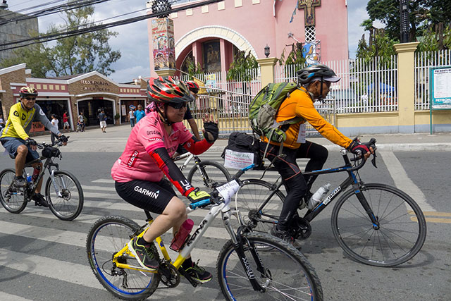 Fr. Picx and biking buddies from the Naawan Bikers (NAB) and the Unified Cycling Clubs of Iligan (UCCI) pass by the St. Michael's Cathedral in downtown Iligan. MindaNews photo by Bobby Timonera