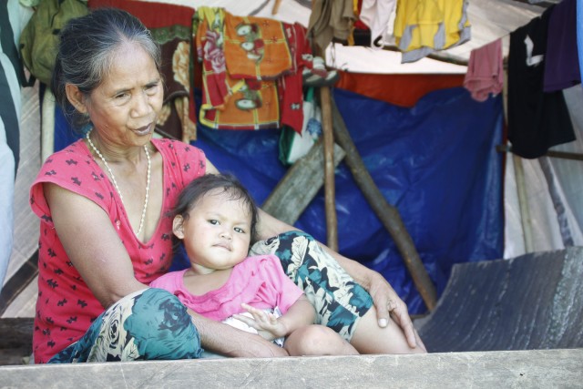 Erlinda Pagalan, a bakwit from Sitio Han-ayan, Barangay Diatagon in Lianga, Surigao del Sur share with a grandchild a small space at the evacuation site in Tandag City on Thursday (1 October 2015). MindaNews photo by H. Marcos C. Mordeno