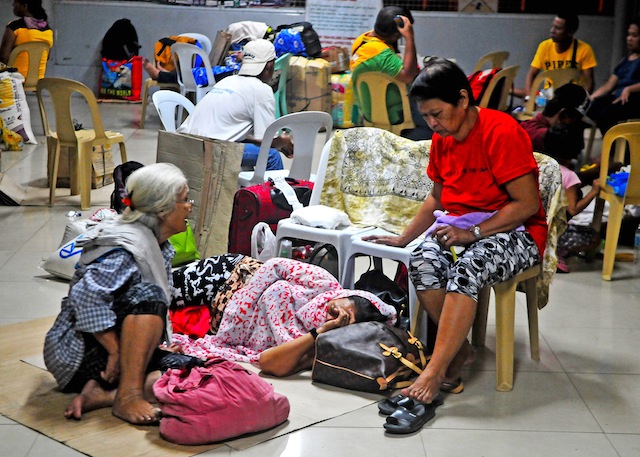 Stranded passengers. Edna Moral of Davao City (in red) and two of her companions rest on the floor of the port terminal in Cagayan de Oro City on Friday, Dec. 18, 2015 after Philippine Coast Guard disallowed ferry services from the port to outlying islands of the Visayas region due to Tropical Depression Onyok. Onyok made landfall in Davao Oriental at 10:30 p.m. Friday but weakened into a low pressure area. MindaNews