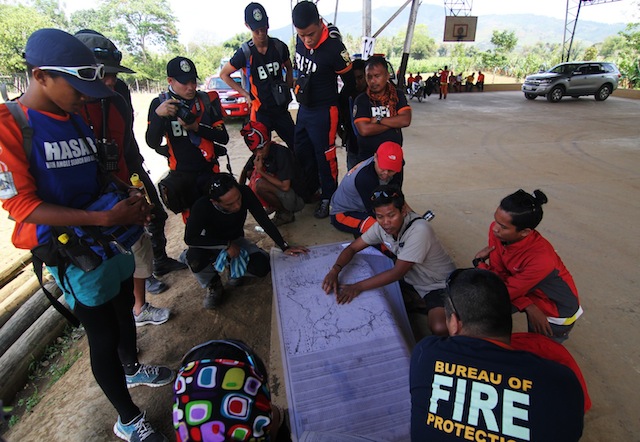 Rye Glen Trinidad, head of the Mindanao Mountaineering Federation (in khaki polo) briefs members of the Bureau of Fire Protection on the Mount Apo trails in Barangay Kapatagan, Davao del Sur on Monday, March 28, 2016. The fire started at the peak last Saturday afternoon. MindaNews photo by TOTO LOZANO