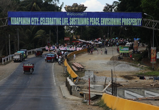  Some of the protesting farmers and members of militant groups gathered near the arch welcoming visitors to Kidapawan City at the boundary with Makilala town in North Cotabato on March 30, 2016. The protesters, (5,000 according to organizers and estimated at 3,000 by the police), are demanding, among others, the release of 15,000 sacks of rice as calamity assistance. MindaNews photo by TOTO LOZANO 