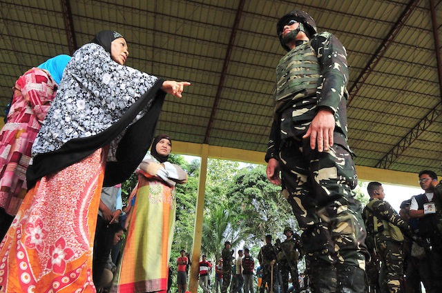 SCOLDED. An Army soldier is scolded by female supporters of a local candidate who were trying to prevent the delivery of vote counting machines in Madalum town, Lanao del Sur on Friday, May 6, 2016. MindaNews photo by FROILAN GALLARDO 