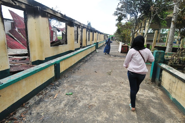 ANOTHER SCHOOL SET ON FIRE. A student passes by the Ragayan Elementary school in Barangay Ragayan in Poonabayabao town, Lanao del Sur on Monday, May 9, 2016. The 16-classroom school was torched by unidentified persons . The voting continued with Comelec officials transfering the voters to another venue. MindaNews photo by FROILAN GALLARDO 