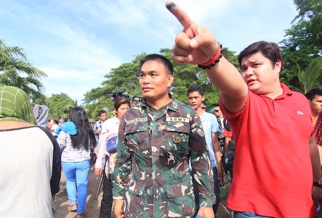 SAJID IN RED. Sajid Islam Uy Ampatuan, youngest son of the late patriarch, Andal Ampatuan, Sr., airs his complaints about the election process to Lt. Col. Edgar delos Reyes, commander of the 40th Infantry Battalion. Sajid is running for mayor of Shariff Aguak town in Maguindanao under the United Nationalist Alliance (UNA) but he and his escorts wore red, the color of Presidential frontrunner Rodrigo Duterte of the Partido ng Demokratikong Pilipino. MindaNews photo by TOTO LOZANO 