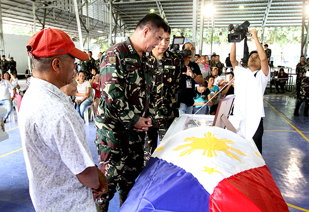 Maj. Gen. Rafael Valencia (second from right) pays his respects to Cpl. Rolen Roy Sarmiento, one of four soldiers killed in two separate encounters with the New Peoples Army (NPA) in Compostela Valley province on August 5. Twelve other soldiers belonging to the Army's 25th Infantry Battalion were also injured. MindaNews photo by KEITH BACONGCO