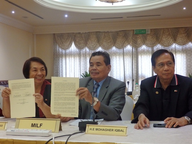 Peace Implementing panel chairs Irene Santiago of the GPH and Mohagher Iqbal of the MILF show reporters their signed Joint Statement, with Presidential Adviser on the Peace Process Jesus Dureza. MindaNews photo by Carolyn O. Arguillas 