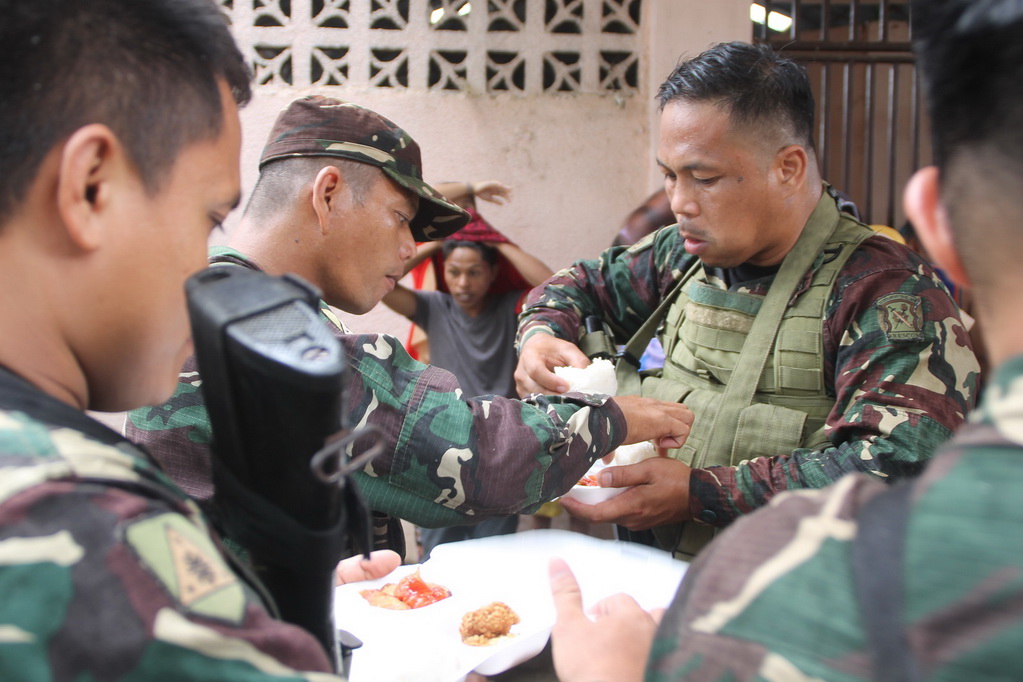 Soldiers take a late lunch after helping in the validation of evacuees from Marawi City at the covered court in Balo-i, Lanao del Norte on Tuesday, 30 May 2017. MindaNews photo by H. Marcos C. Mordeno
