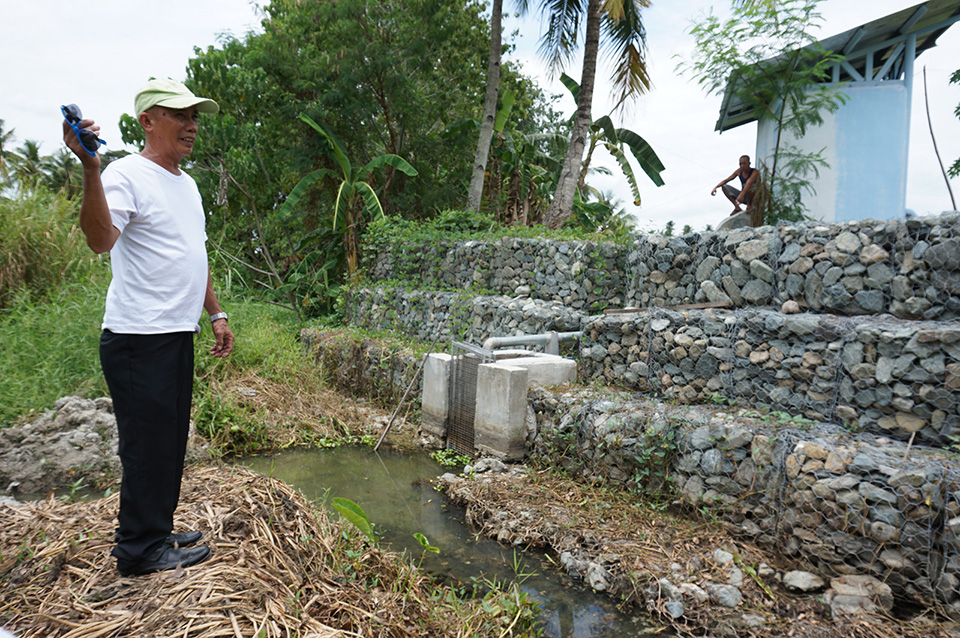 Kagawad Danilo Casa of Brgy. Biwang, Bagumbayan, Sultan Kudarat shows the uncemented riprap at the solar-powered irrigation project site in his brother's farm. MindaNews photo by H. MARCOS C. MORDENO